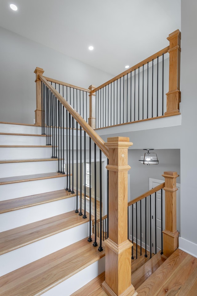 stairs with recessed lighting, baseboards, and wood finished floors