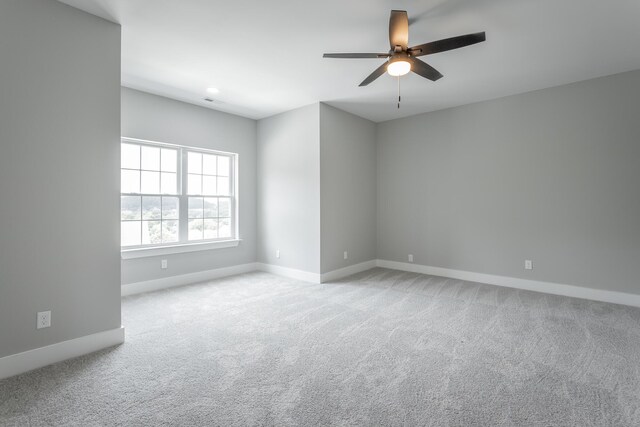 spare room with baseboards, a ceiling fan, and carpet