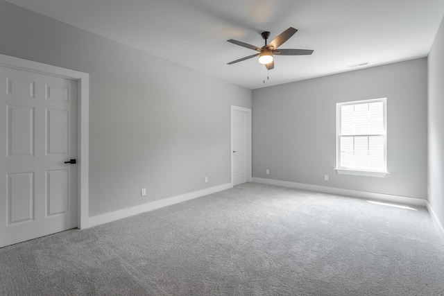 empty room with visible vents, a ceiling fan, carpet, and baseboards