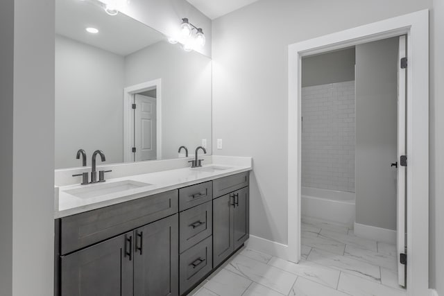 full bathroom featuring baseboards, a sink, marble finish floor, and double vanity