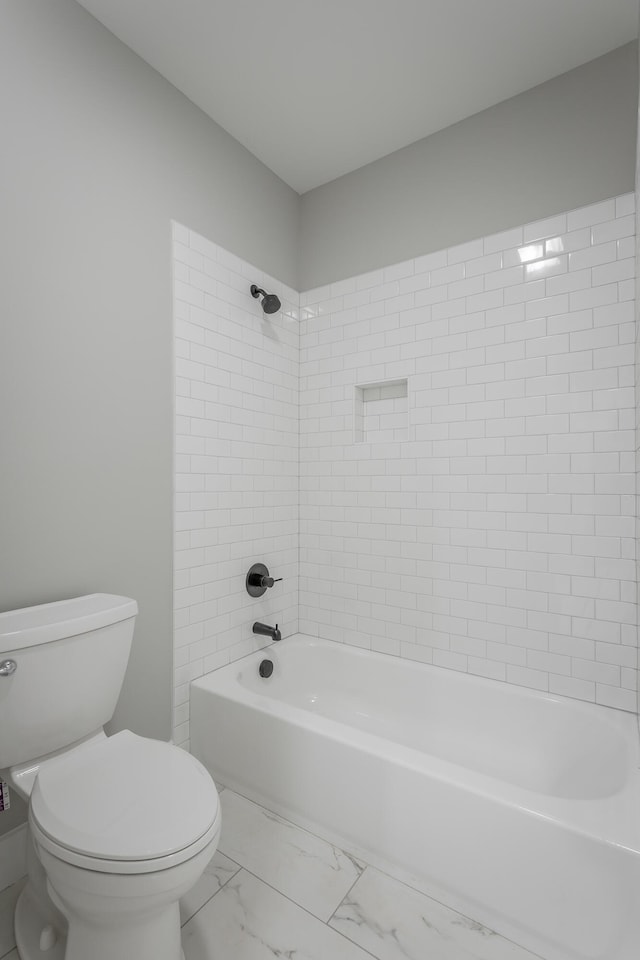 bathroom featuring tiled shower / bath and toilet