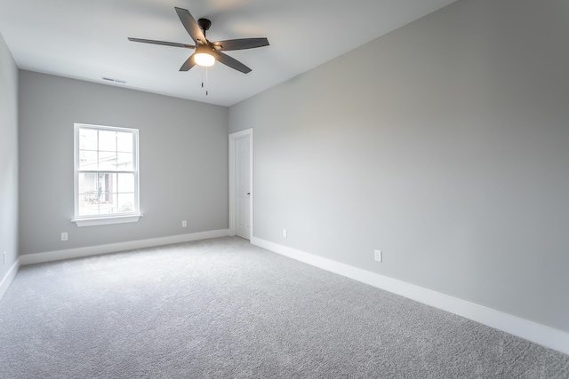 spare room with a ceiling fan, baseboards, and light carpet