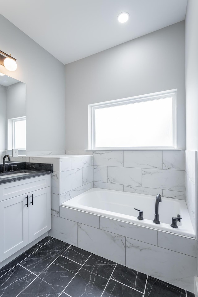 bathroom with vanity and a relaxing tiled tub