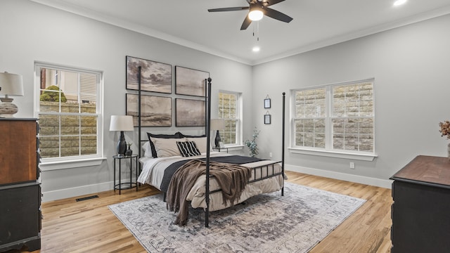 bedroom with baseboards, ornamental molding, wood finished floors, and visible vents