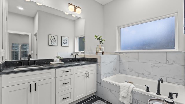 full bathroom with a sink, a garden tub, recessed lighting, and double vanity