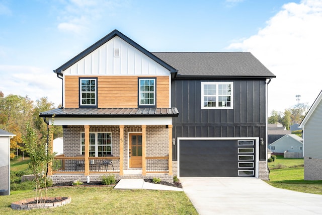 view of front of property with a garage, covered porch, and a front yard