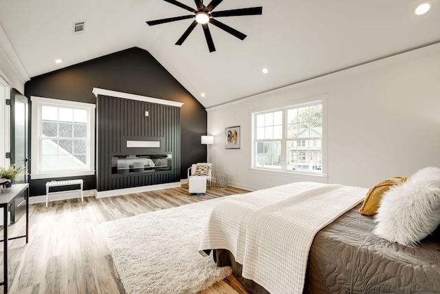 bedroom featuring lofted ceiling, multiple windows, ceiling fan, and wood-type flooring