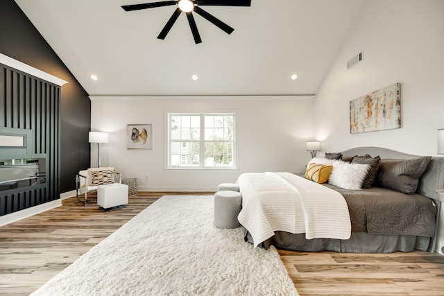 bedroom with light hardwood / wood-style floors, ceiling fan, and vaulted ceiling