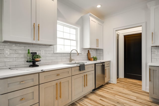 kitchen with light stone counters, stainless steel dishwasher, crown molding, backsplash, and light wood-type flooring