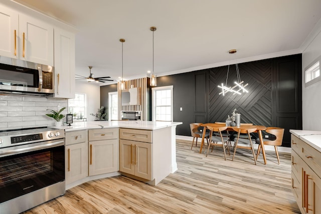 kitchen featuring plenty of natural light, hanging light fixtures, and stainless steel appliances