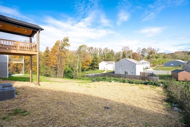 view of yard featuring a deck and a storage unit