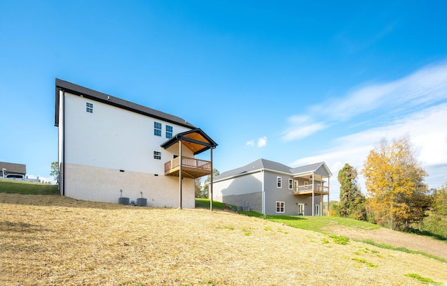 back of property featuring central AC unit and a balcony