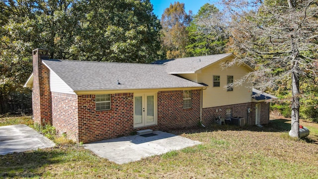 view of front of home featuring french doors, a patio area, a front yard, and central AC unit