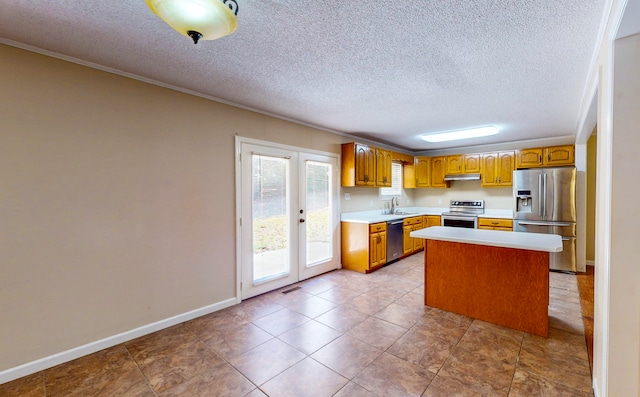 kitchen with a kitchen island, french doors, sink, appliances with stainless steel finishes, and a textured ceiling