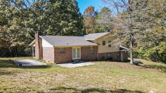 split level home featuring a patio, a front yard, and central air condition unit