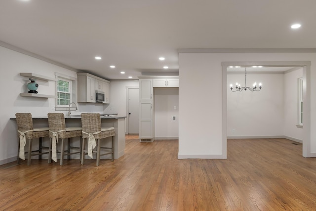 4011 Patton Edwards Dr, Chattanooga, TN 37412 - kitchen with stainless steel microwave, a peninsula, recessed lighting, a breakfast bar, and a chandelier