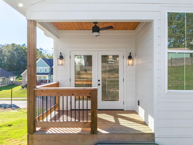 exterior space featuring a wooden deck, a lawn, and ceiling fan