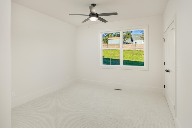 unfurnished room with light colored carpet and ceiling fan