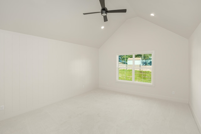 empty room featuring light carpet, ceiling fan, and vaulted ceiling