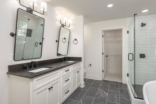 bathroom with a shower with door, vanity, and toilet