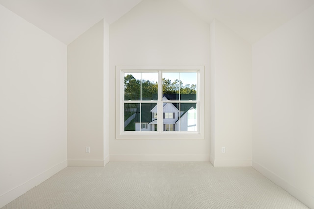 carpeted empty room with lofted ceiling