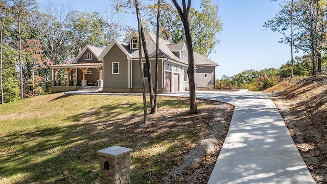 view of front of property featuring a front yard, a porch, and a garage