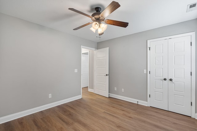 unfurnished bedroom with light hardwood / wood-style floors, ceiling fan, and a closet