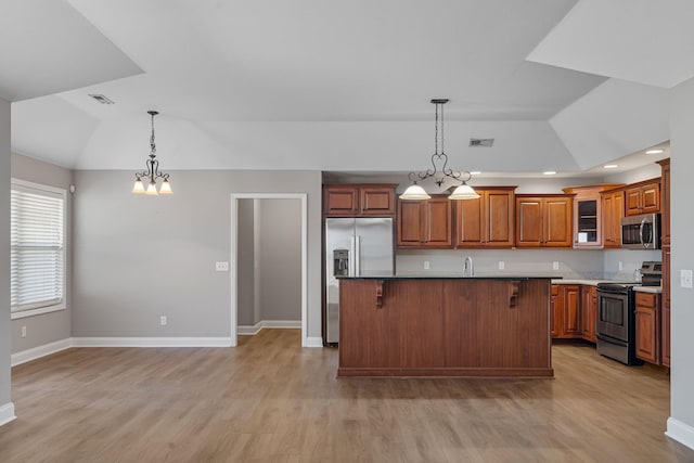 kitchen featuring stainless steel appliances, a kitchen island, a breakfast bar, and lofted ceiling