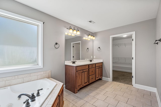 bathroom featuring vanity and tiled tub