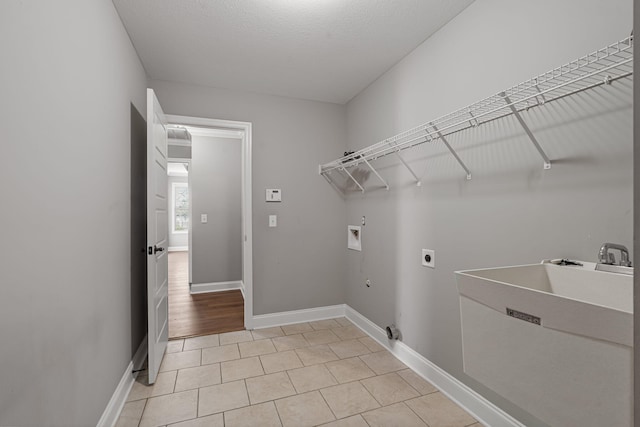 clothes washing area with washer hookup, electric dryer hookup, a textured ceiling, and gas dryer hookup