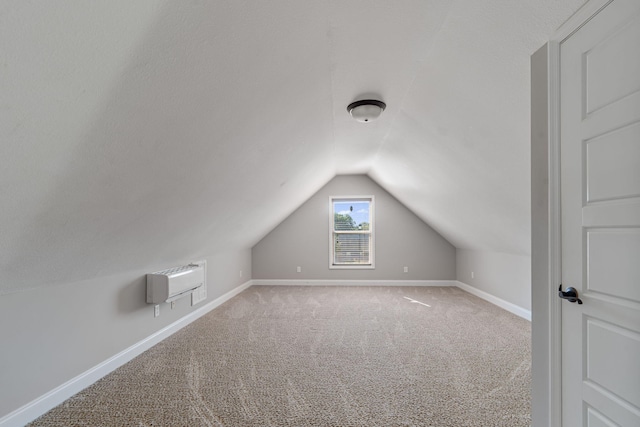 bonus room featuring carpet, vaulted ceiling, and a wall mounted air conditioner