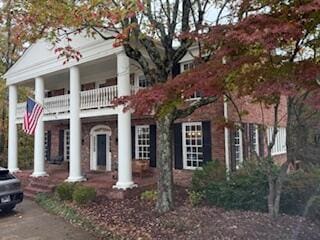 greek revival inspired property featuring a balcony