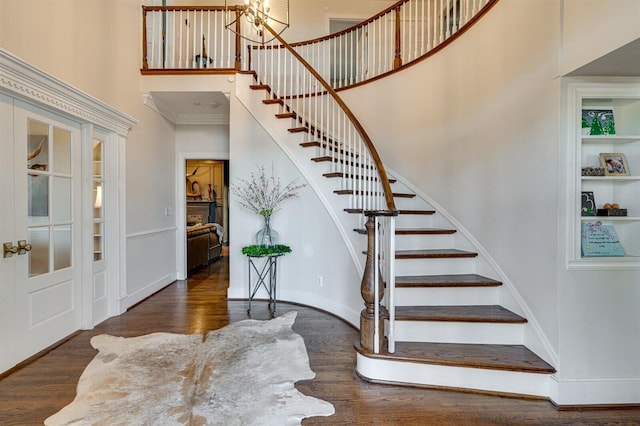 entryway with a notable chandelier, dark wood-type flooring, and a high ceiling