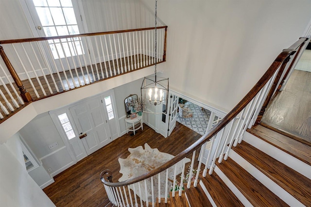 entryway featuring a high ceiling, dark hardwood / wood-style floors, and an inviting chandelier