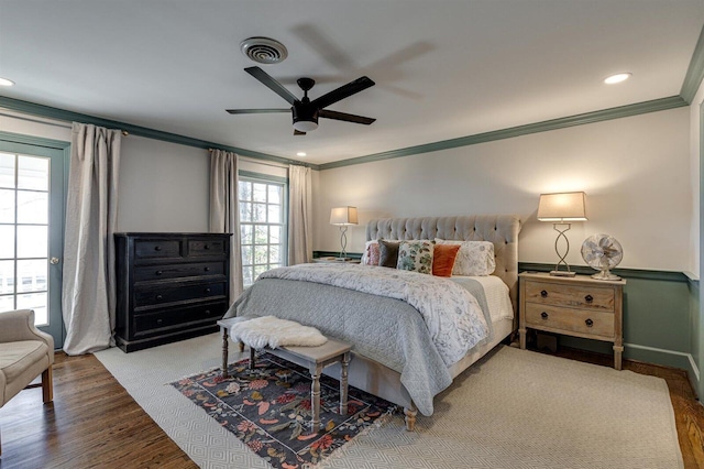 bedroom featuring hardwood / wood-style flooring, ornamental molding, and ceiling fan