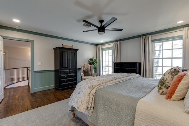 bedroom with crown molding, dark wood-type flooring, and ceiling fan