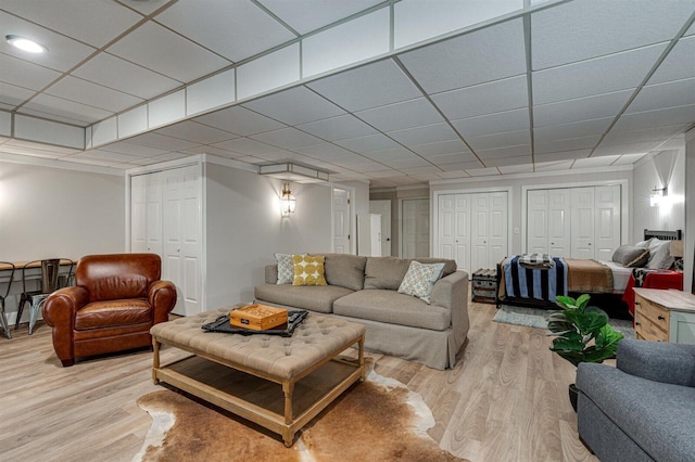 living room with a drop ceiling and light hardwood / wood-style flooring