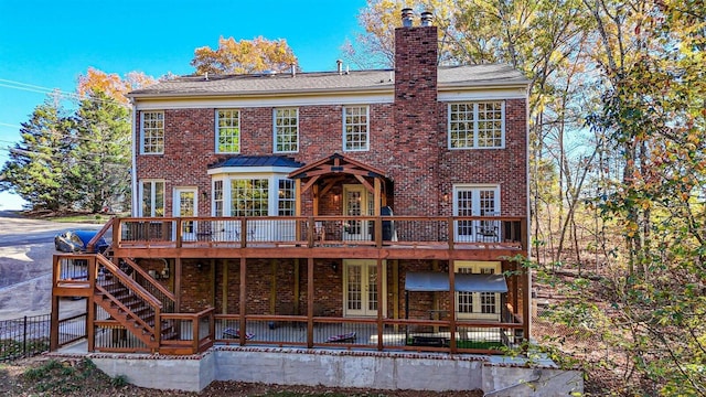 rear view of property with a wooden deck and french doors