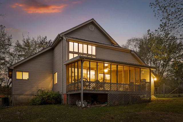 back house at dusk with a yard and cooling unit