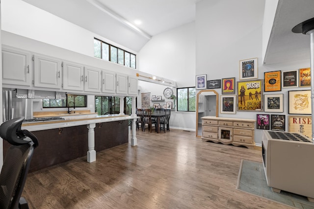 interior space featuring sink, dark wood-type flooring, white cabinets, and high vaulted ceiling