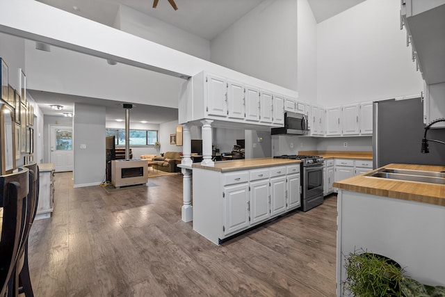 kitchen featuring white cabinetry, ornate columns, appliances with stainless steel finishes, and sink