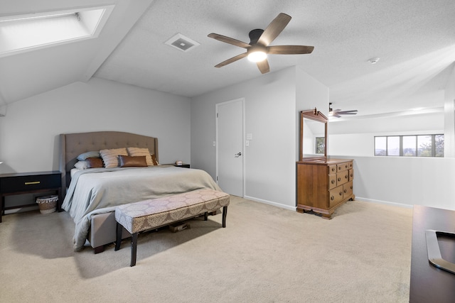 carpeted bedroom featuring lofted ceiling with skylight and ceiling fan