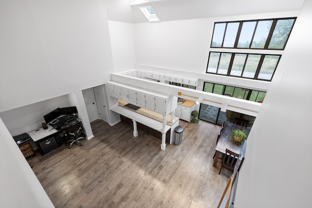 miscellaneous room with wood-type flooring and a high ceiling