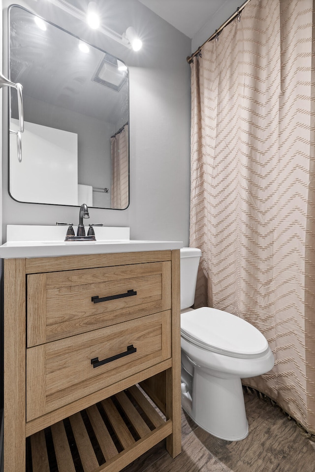 bathroom with vanity, wood-type flooring, and toilet