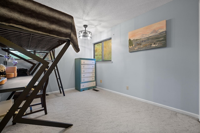 bedroom with a textured ceiling and carpet flooring