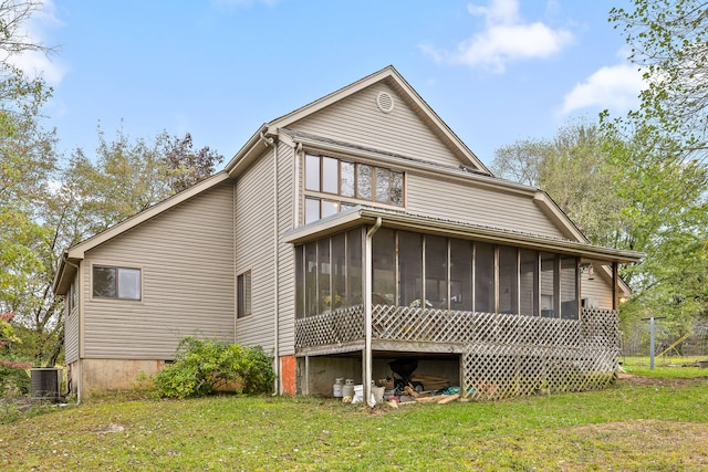 back of house featuring a sunroom, a lawn, and central AC unit