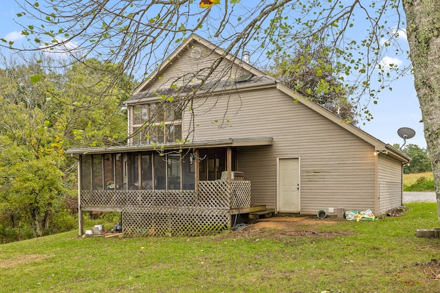 rear view of house with a sunroom and a lawn