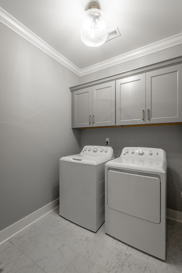 clothes washing area featuring ornamental molding, independent washer and dryer, and cabinets