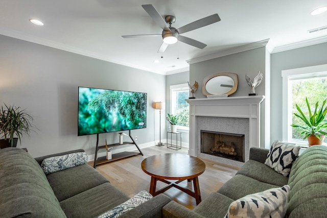 living room with ceiling fan, ornamental molding, and light hardwood / wood-style flooring