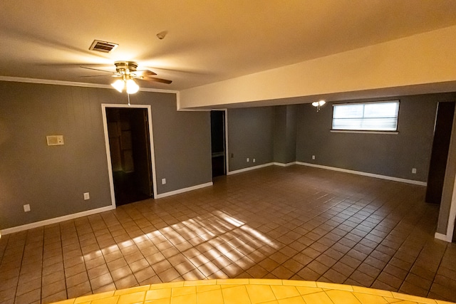 tiled empty room with ceiling fan and crown molding